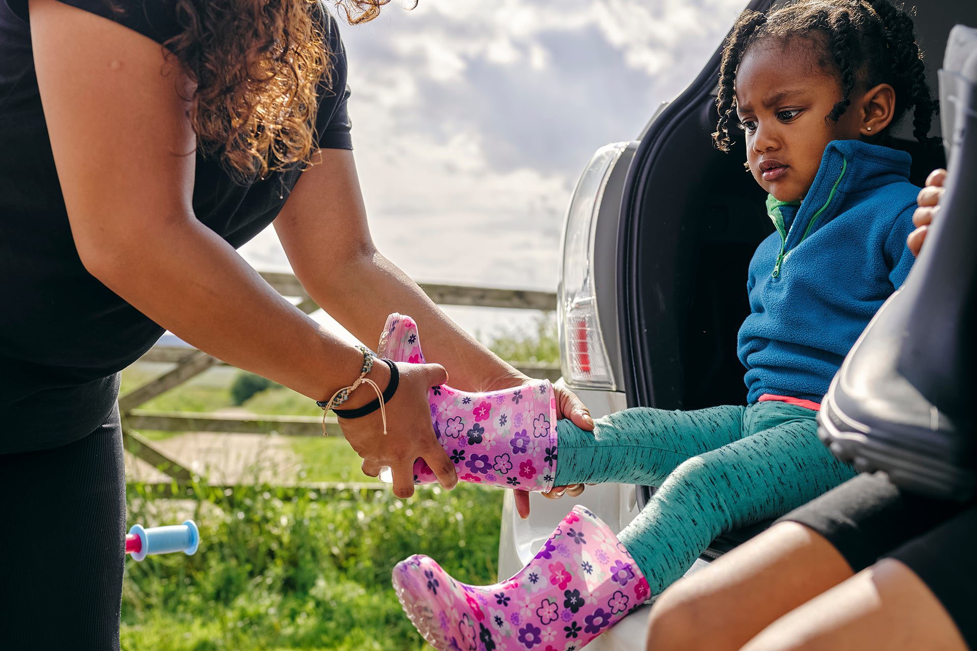 Mum putting on childs wellies